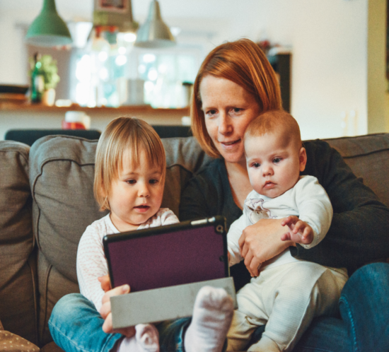 Frau mit zwei Kindern im Home Office